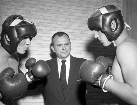 Photo of Bill Moody giving instructions to young men preparing to box