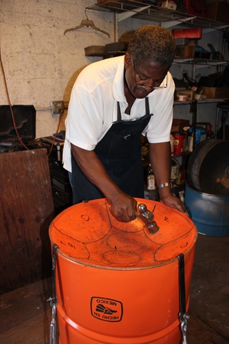 Photo of Michael Kernahan making a steel pan drum